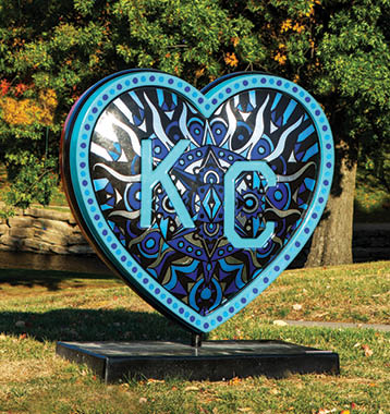 A blue heart-shaped sculpture is displayed in a park, surrounded by trees. AI generated content
