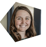 A woman with long hair and a green shirt is smiling for the camera. AI generated content