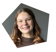 A woman with long brown hair and a brown sweater is smiling for the camera. AI generated content