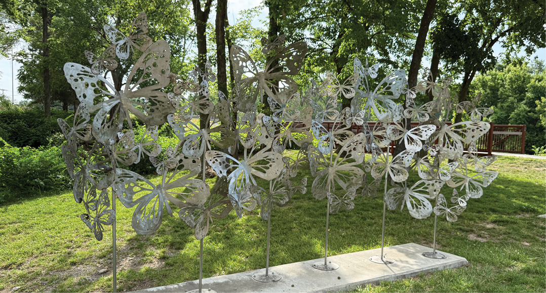 A group of metal butterflies are displayed in a park. AI generated content
