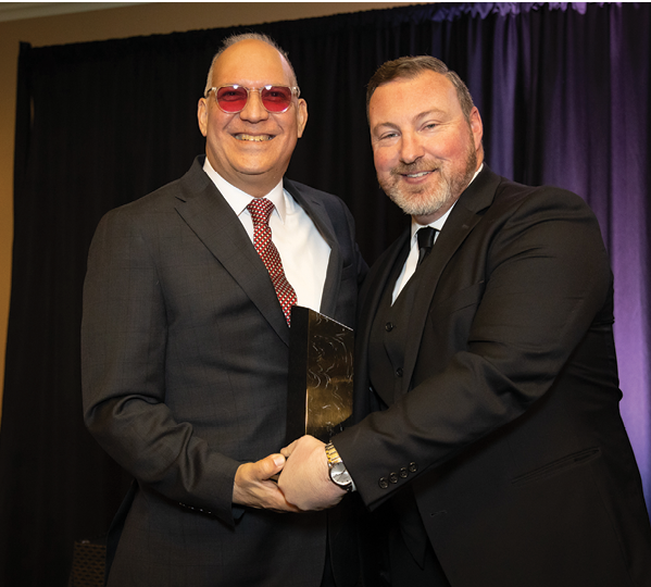 Two men in suits are shaking hands, one of them holding an award. AI generated content