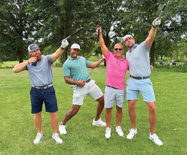 Four men are standing in a grassy field, holding golf clubs and celebrating. AI generated content