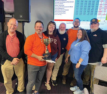 A group of people pose for a photo with a trophy. AI generated content