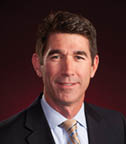 A man wearing a suit and tie is smiling for the camera. AI generated content