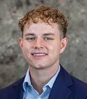 A man wearing a blue suit and white shirt is smiling for the camera. AI generated content