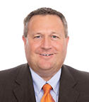 A man wearing a suit and tie with an orange tie. AI generated content
