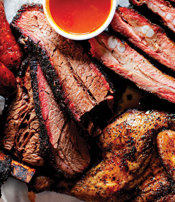 BBQ. Barbecue table spread. Beef brisket, chicken, pork ribs, beef ribs, Mac n cheese, cornbread, Brussels sprouts, coleslaw & beer. Classic traditional Texas meats & side dishes.