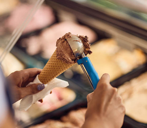 Ice cream chocolate in a cone, put with a scooper.