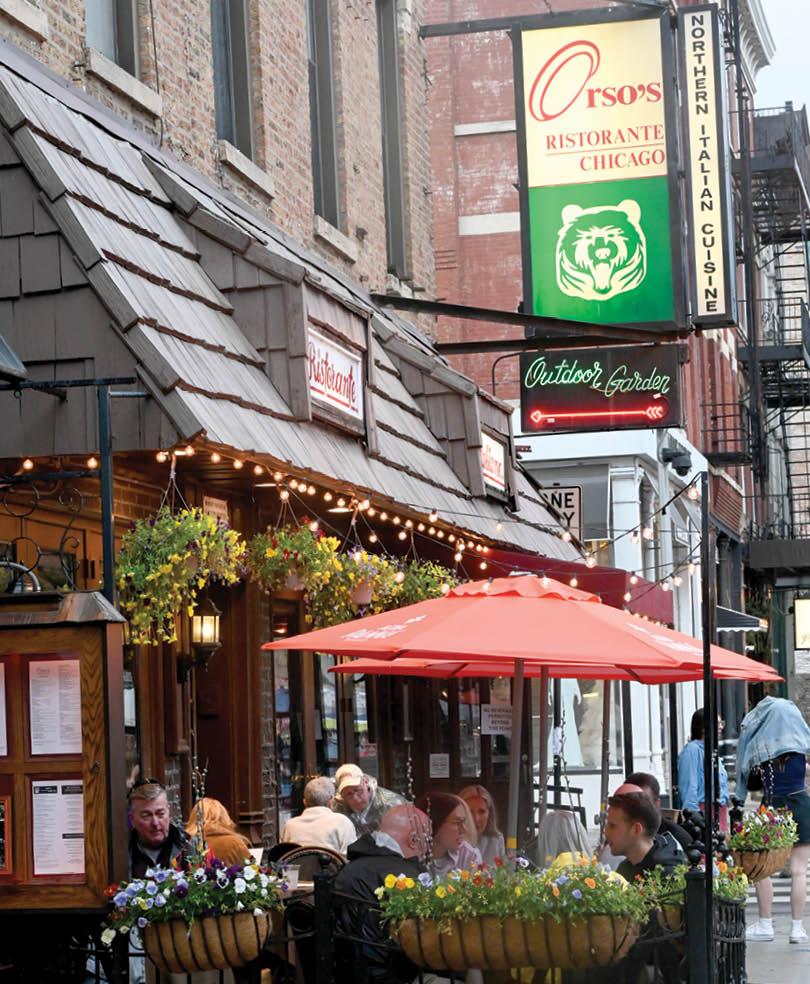 A restaurant with a red umbrella and a green sign. Description generated by AI