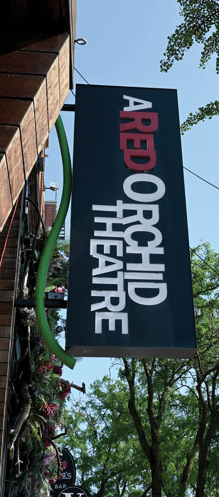 A black and white sign with red letters that says “Red Orchid Theatre". Description generated by AI