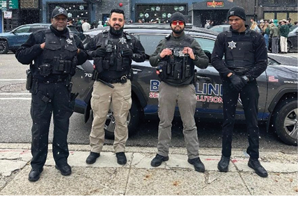 Four men standing in front of a car. Description generated by AI
