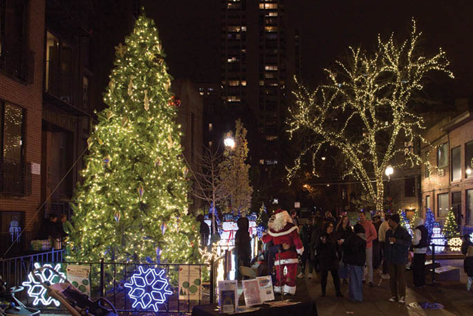 A lit up Christmas tree in the middle of a city street. Description generated by AI