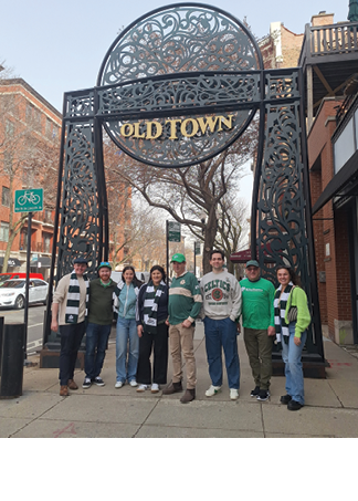 A group of people are standing in front of a sign that says Old Town. Description generated by AI