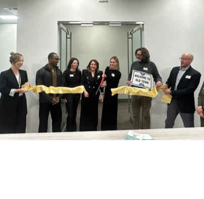 A group of people are standing in front of a door with a yellow ribbon on it. Description generated by AI