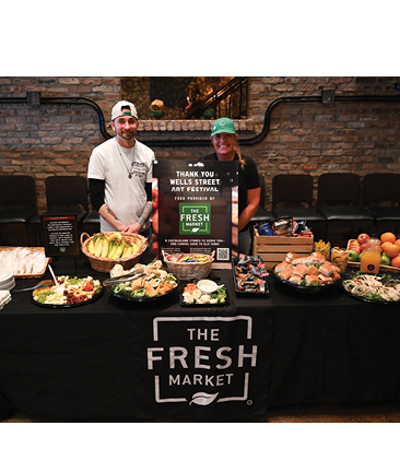 A table with food on it and a sign that says “The Fresh Market". Description generated by AI