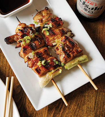 A plate with two skewers of meat and vegetables. Description generated by AI