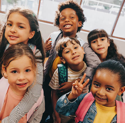 Class selfie in an elementary school. Kids taking a picture together in a co-ed school. Group of elementary school children feeling excited to be back at school.