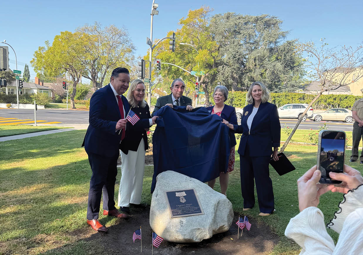 A group of people are standing around a stone with a black cloth on it. Description generated by AI