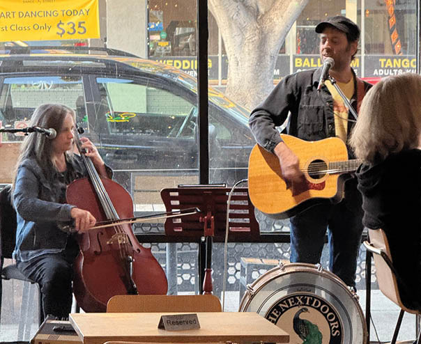 A man and a woman playing music in a restaurant. Description generated by AI
