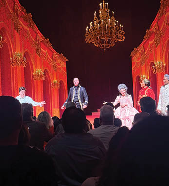 A group of people are performing on stage in front of a large crowd. Description generated by AI