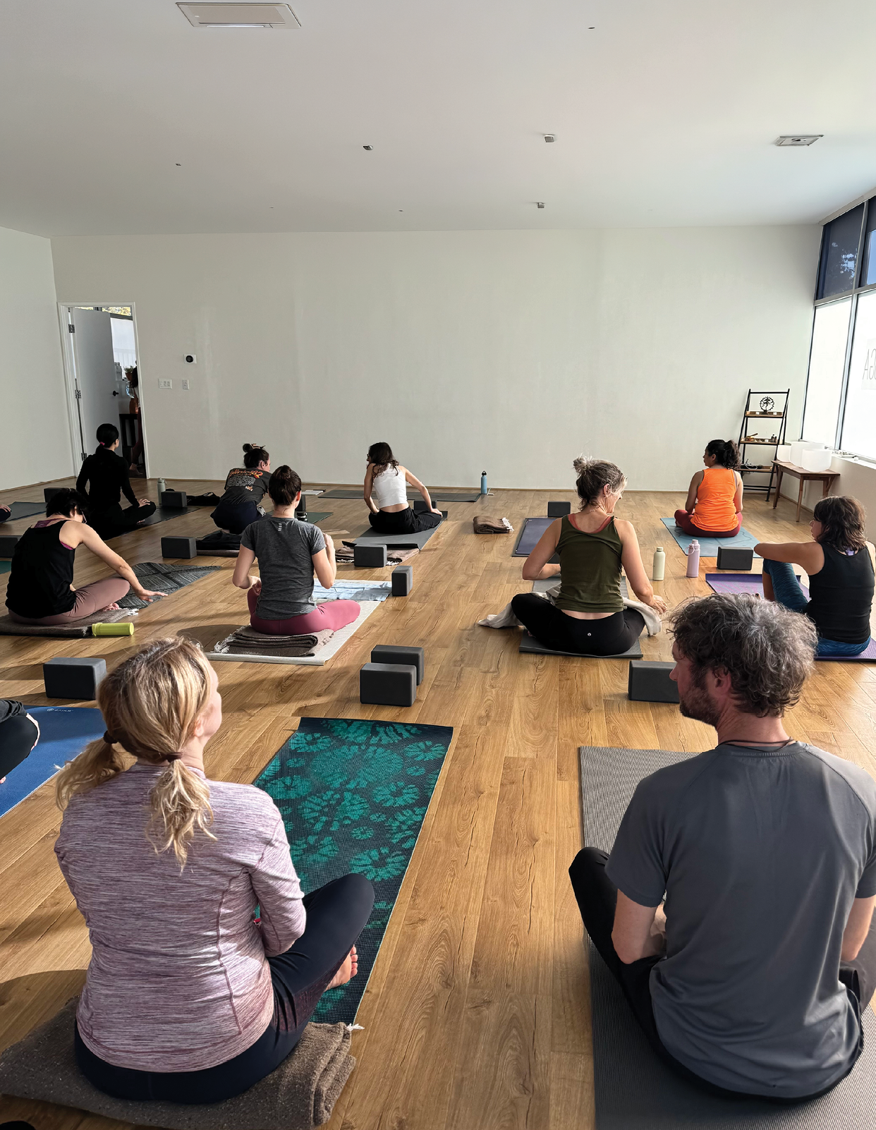 A group of people are sitting on the floor in a room. Description generated by AI