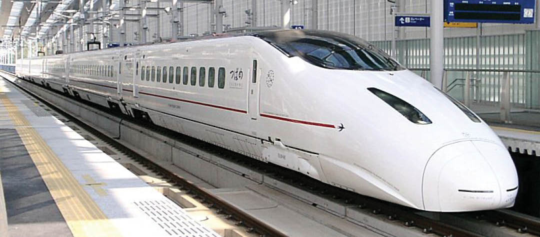 A white and red train on the tracks. Description generated by AI