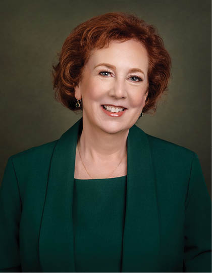 A woman wearing a green jacket and a green shirt is smiling for the camera. AI generated content