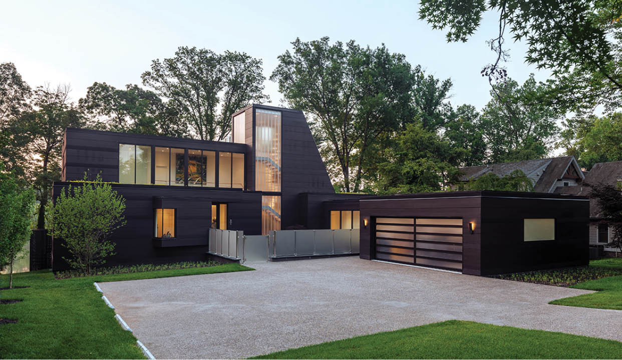 A large black house with a white driveway. Description generated by AI