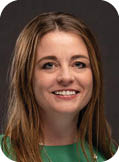 A woman wearing a green shirt and a gold necklace. Description generated by AI