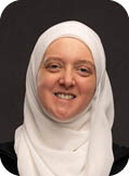 A woman wearing a white head scarf. Description generated by AI
