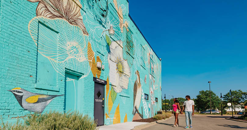 A blue building with a mural on it. Description generated by AI