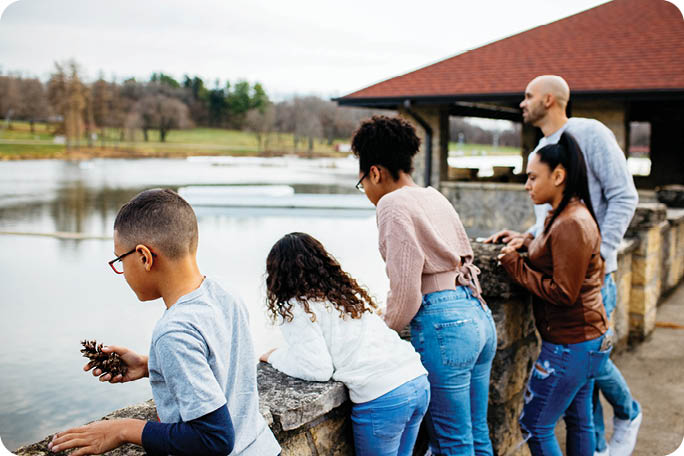 A group of people standing on a bridge overlooking a body of water. Description generated by AI