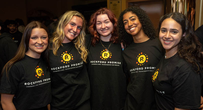 Five women wearing black shirts with the word “Rockford" on them. AI generated content