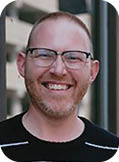 A man wearing a black and white striped shirt. Description generated by AI
