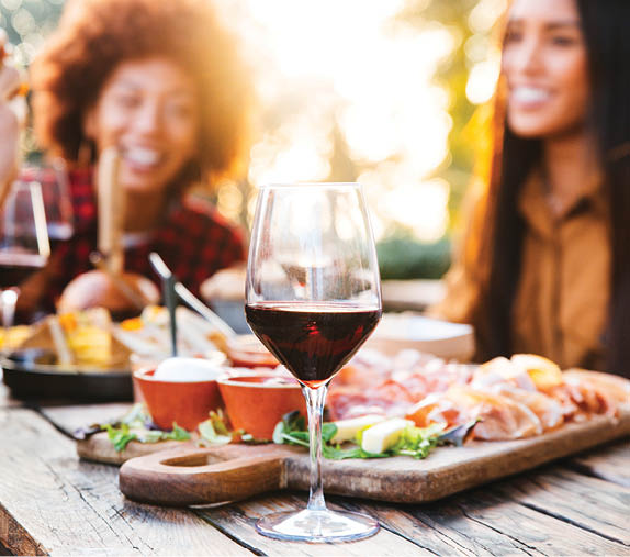 Happy family having barbecue party in backyard - Young friends celebrating at dinner drinking red wine at sunset - Focus on wine glass
