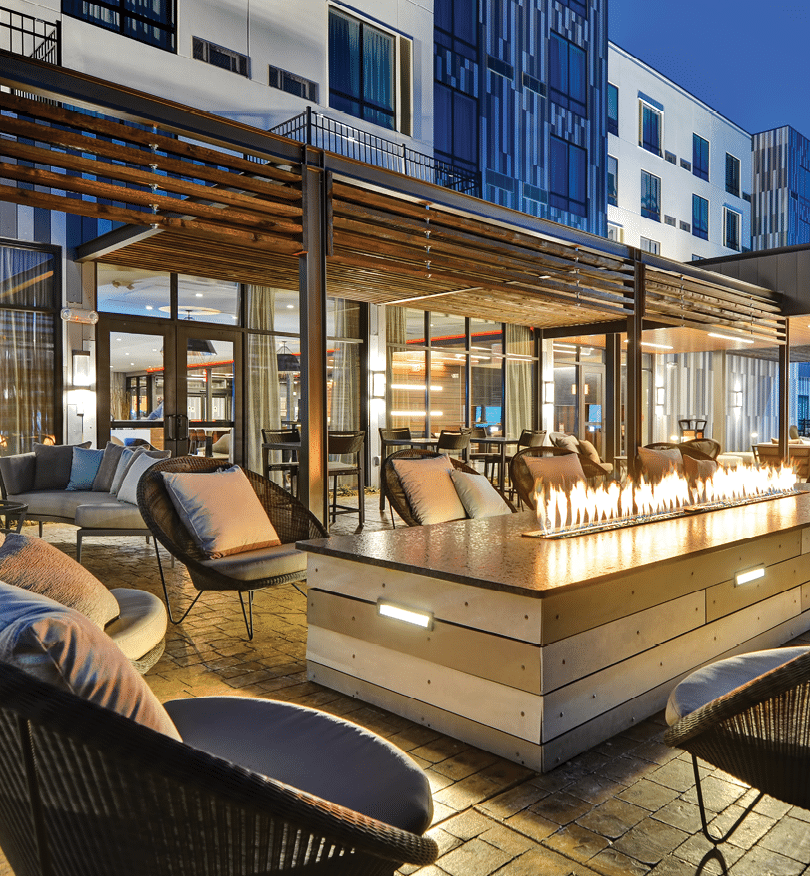 A patio with a fire pit and chairs. Description generated by AI