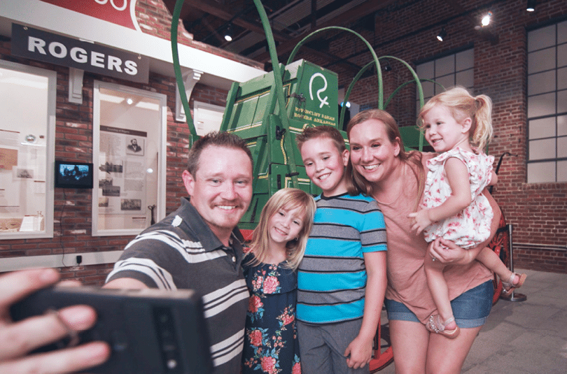 A family poses for a photo in front of a large tractor. AI generated content