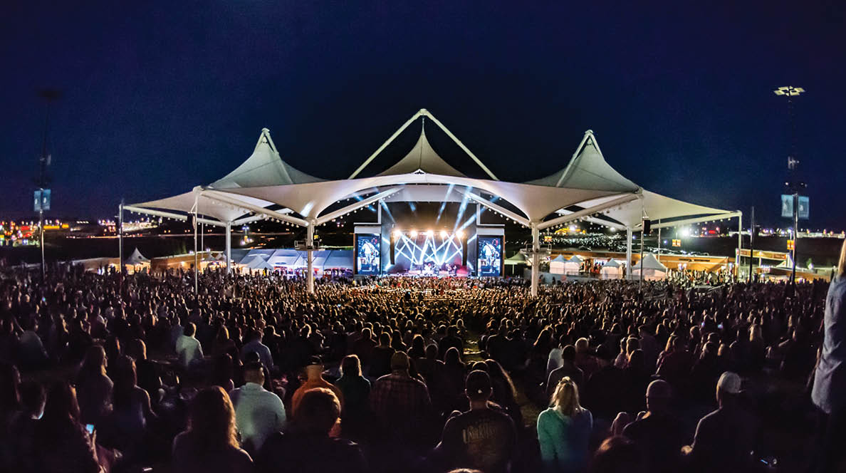 A large crowd of people is gathered in a stadium, watching a concert. AI generated content