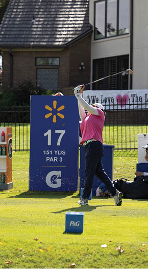 A man is swinging a golf club at a ball on a golf course. AI generated content
