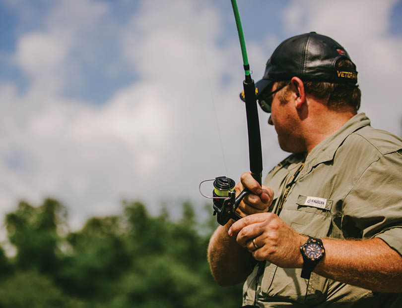 A man wearing a hat and sunglasses is holding a fishing rod. AI generated content