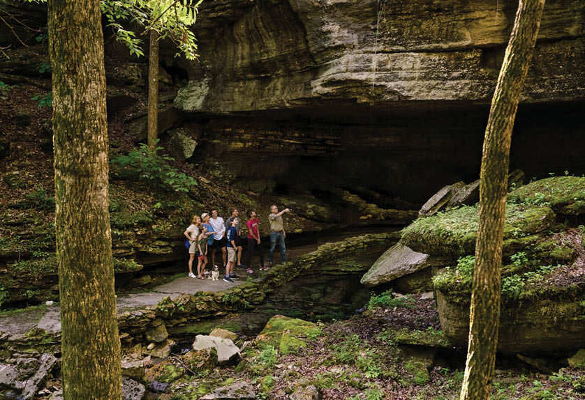 A group of people are standing on a rocky path near a waterfall. AI generated content