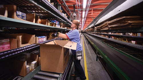 A woman is working in a warehouse, unloading boxes from a conveyor belt. AI generated content