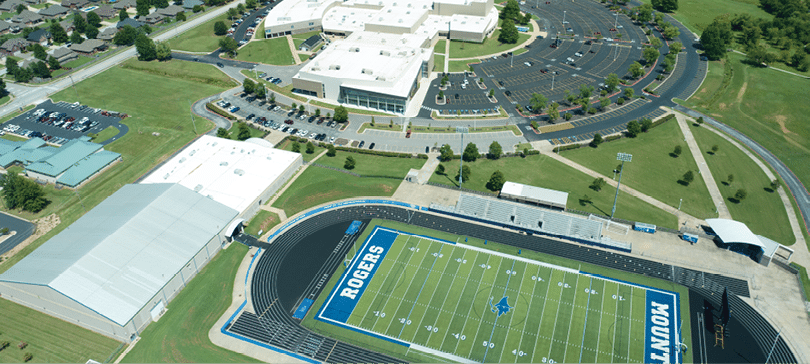 A large football field with a blue and white field and a stadium in the background. AI generated content