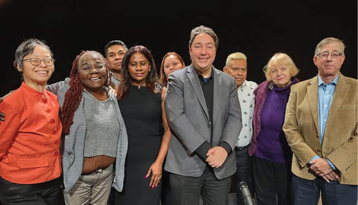 A group of people posing for a picture, including a man in a gray suit and a woman in a black dress. AI generated content
