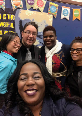 A group of people posing for a picture, including a man wearing glasses and a woman with a scarf. AI generated content