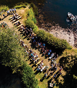 A group of people standing in front of a body of water. Description generated by AI