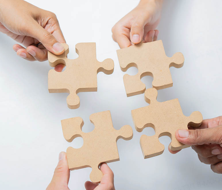 The man and woman holds in hand a jigsaw puzzle. Business solutions, success and strategy concept. Close up, top view.