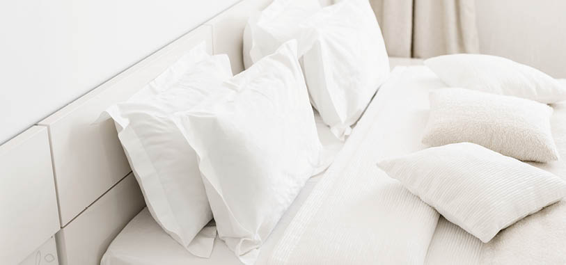 Modern double bedroom. Comfortable soft white pillows on a bed. Inside rooms of a apartment or hotel