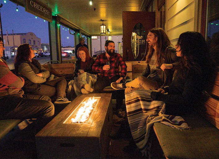 Image of people sitting outside enjoying the fire at the Naughty Oak Brewery 