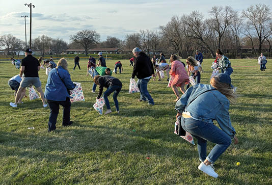 A group of people are playing a game in a field. AI generated content